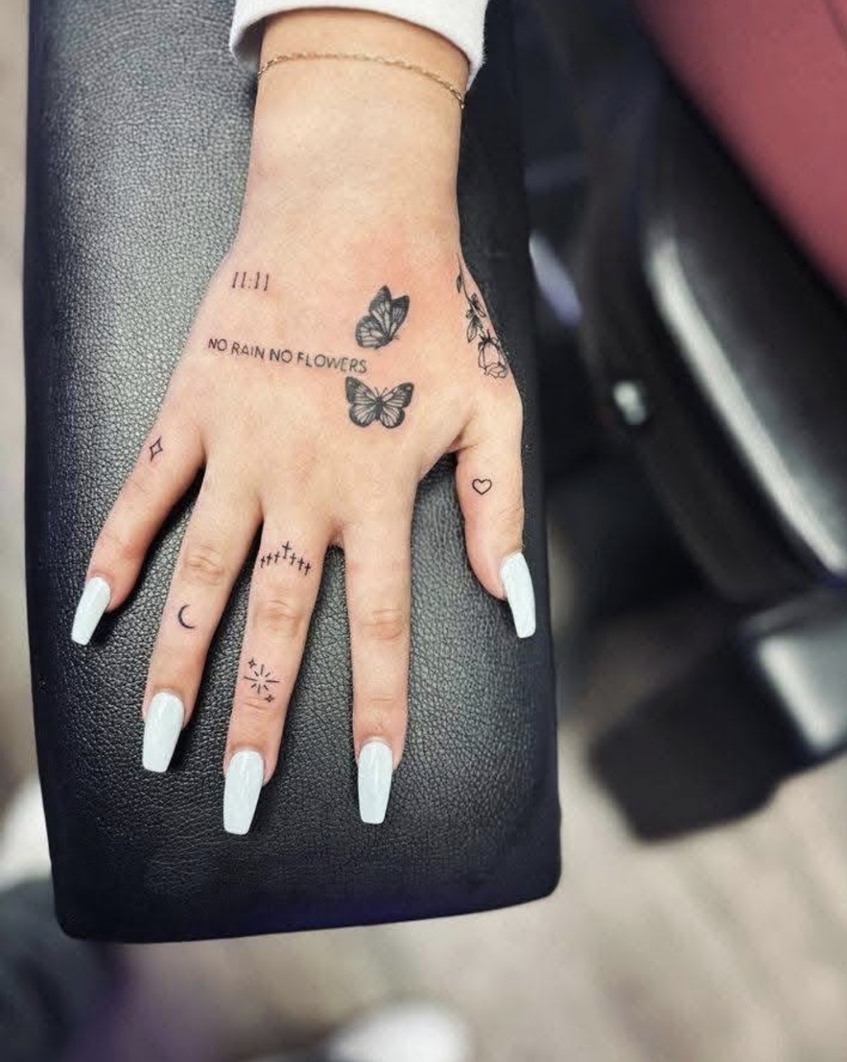 Fine line hand tattoos with butterflies and script