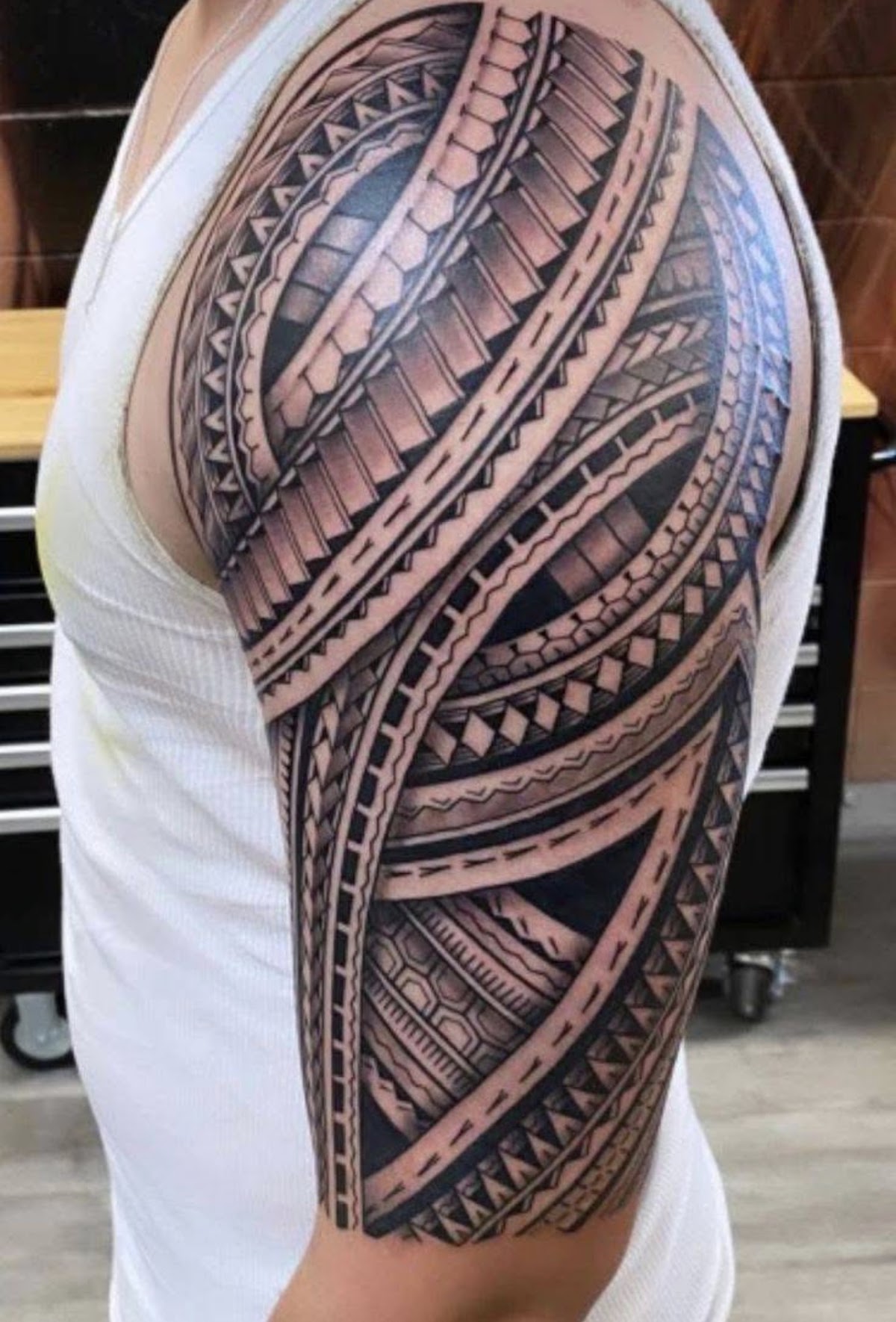 Bold Polynesian tribal half sleeve tattoo on upper arm